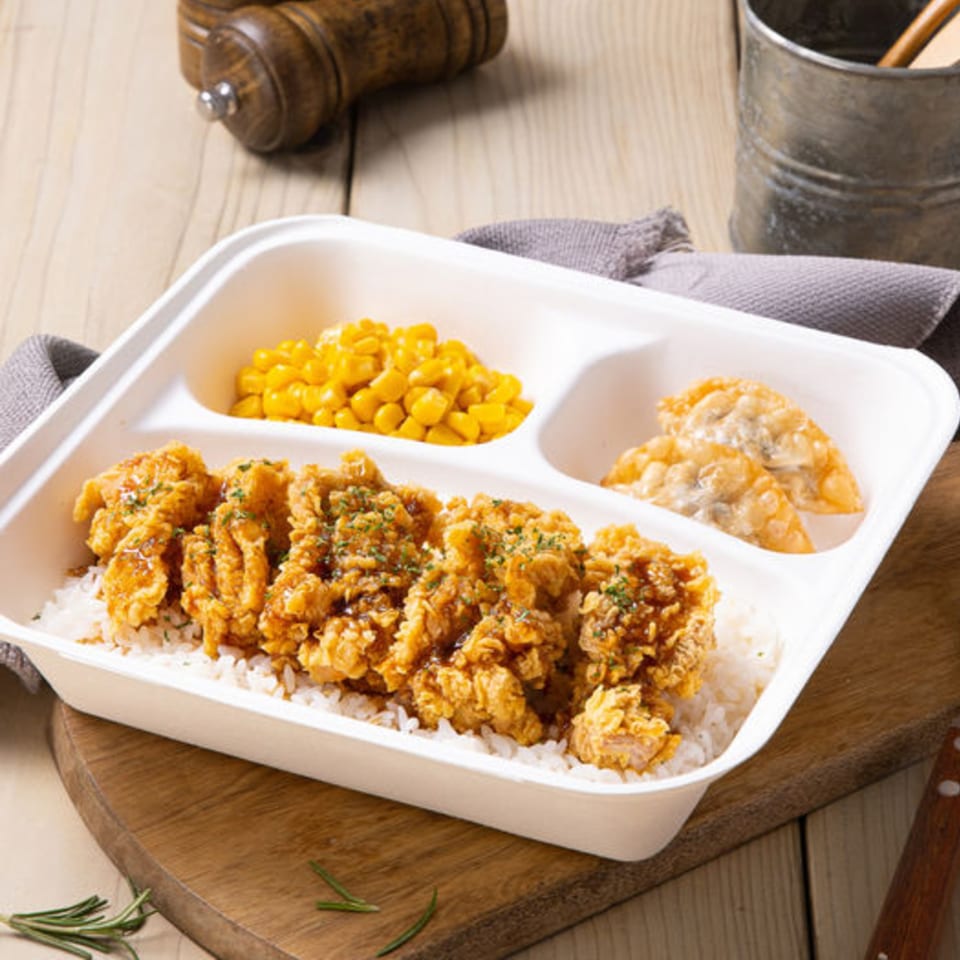 Vons Chicken Waimalu fried chicken rice plate with corn and dumplings on a wooden table.